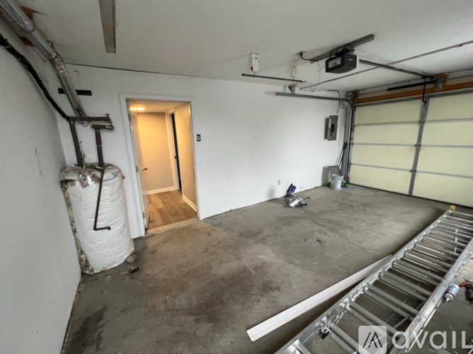 A room with a concrete floor and a door leading to another room.