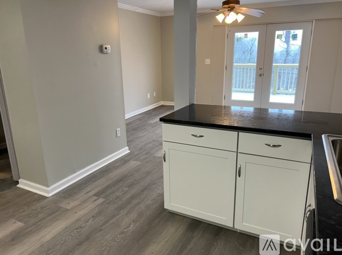 A kitchen with white cabinets and a black countertop.
