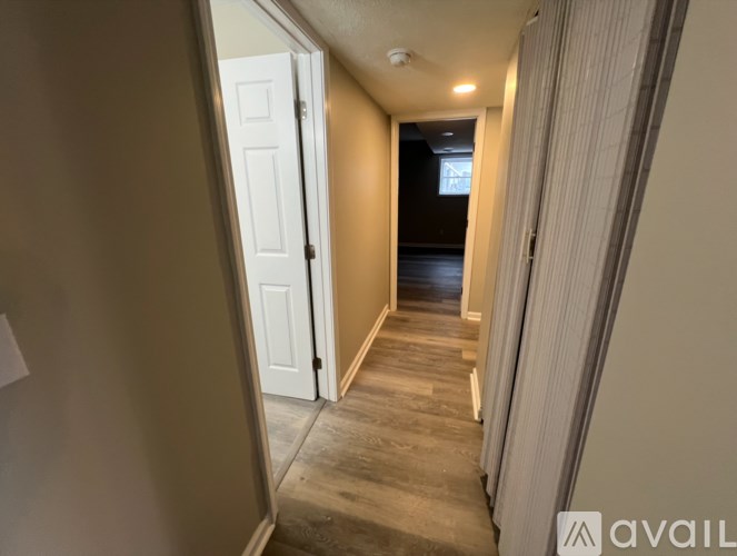 A hallway with a white door and a wooden floor.