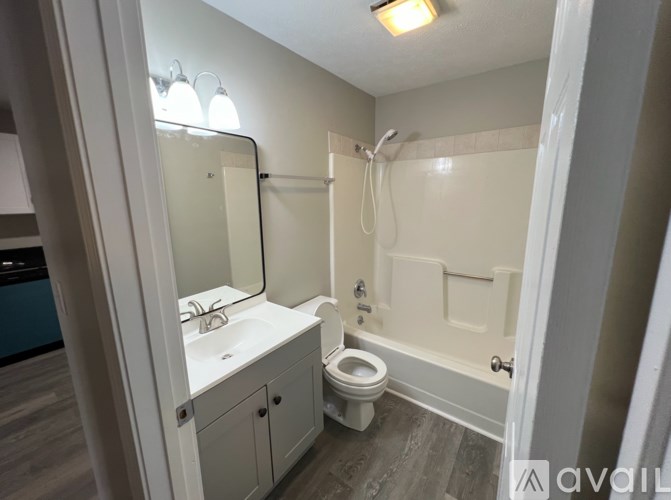 A bathroom with a toilet, sink, and shower.