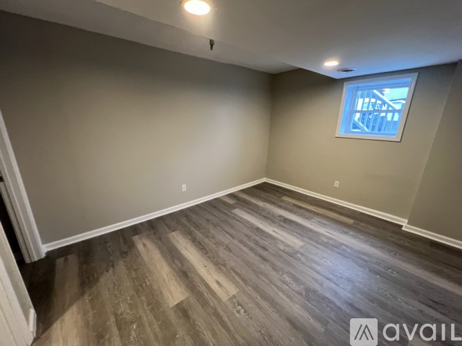 A room with wooden flooring and a window.