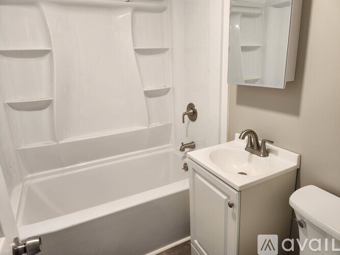 A white bathroom with a toilet, sink, and bathtub.