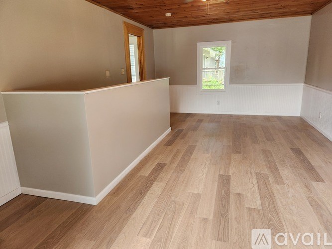 A room with wooden flooring and a window.