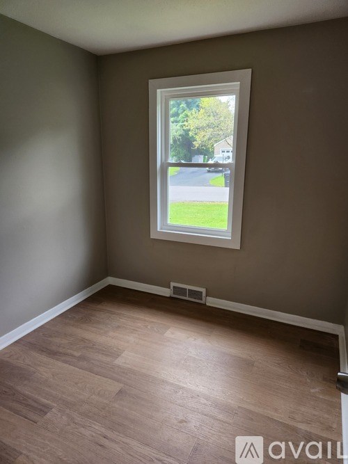 A room with a window showing a street view.