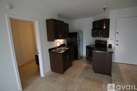 A kitchen with brown cabinets and appliances is available for rent.