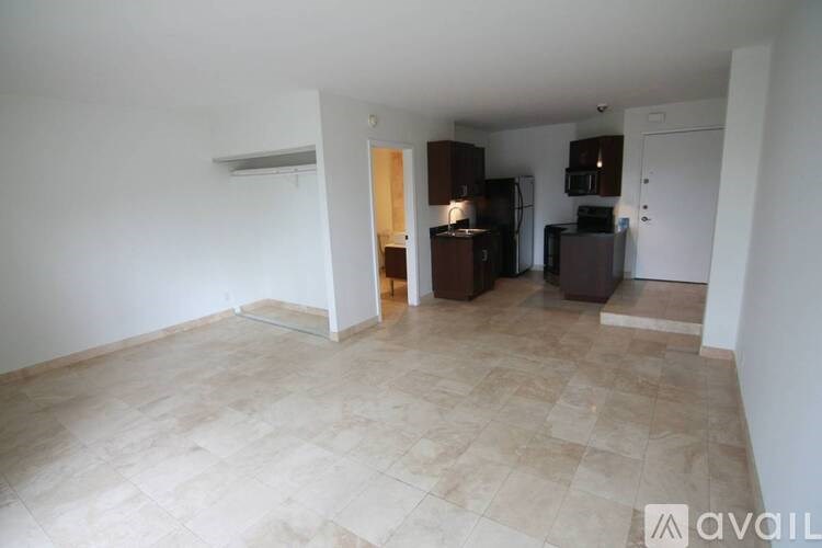 A kitchen area with brown cabinets and appliances in a white room.