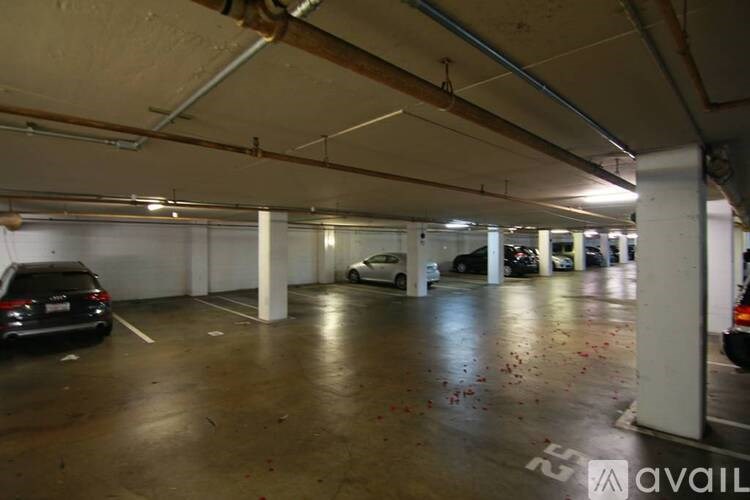 A parking garage with a few cars and a sign that says "available".