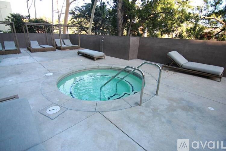 A pool with a greenish water surrounded by four chairs.
