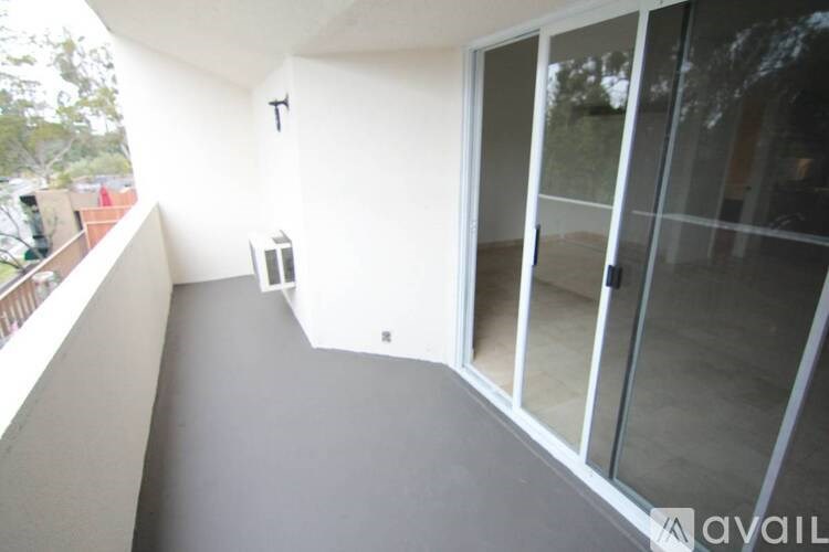 A balcony with a glass door and a small table.