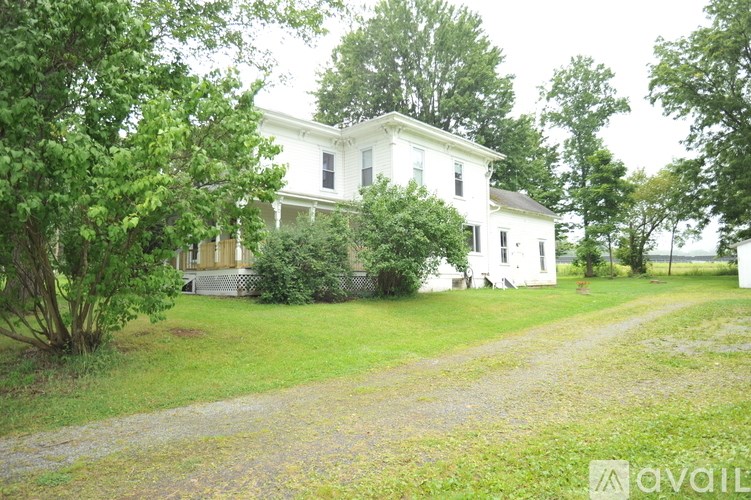A white house with a green lawn in front.