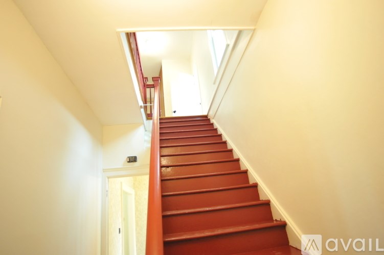 A red staircase with a skylight above it.