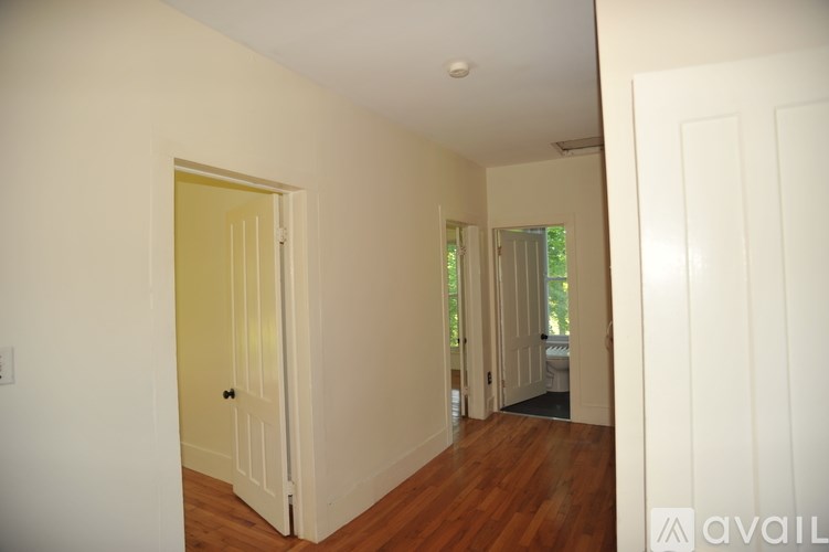 A room with a white door and wooden floors.