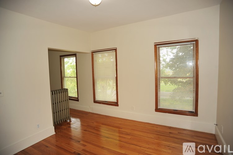 A room with wooden floors and two windows.