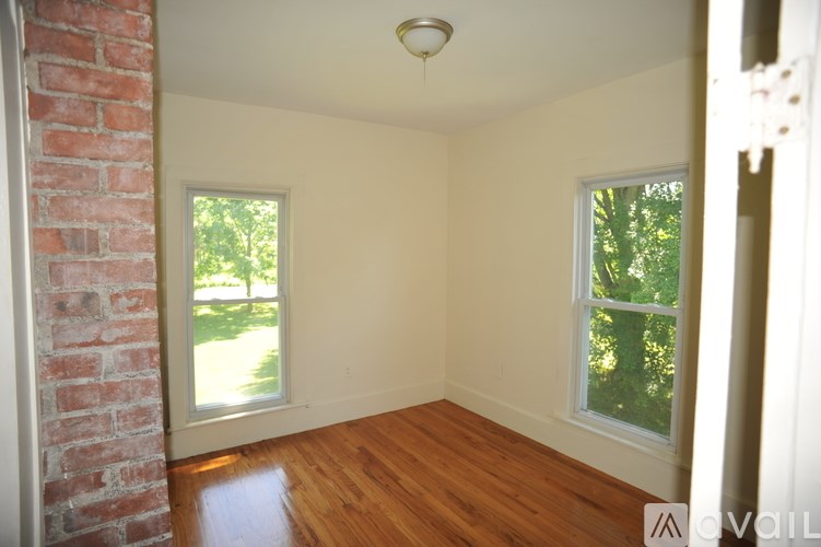 A room with a brick wall and wooden flooring.