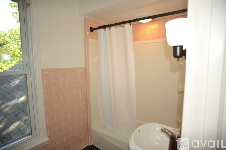 A bathroom with a white shower curtain and a white sink.