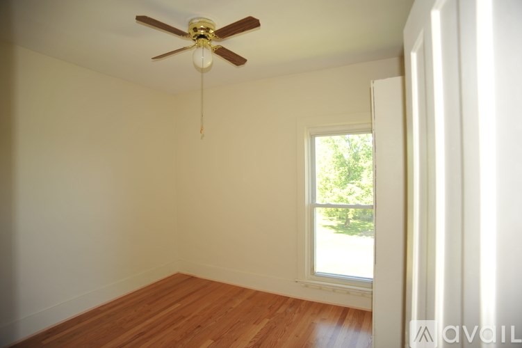 A room with a ceiling fan and a window.