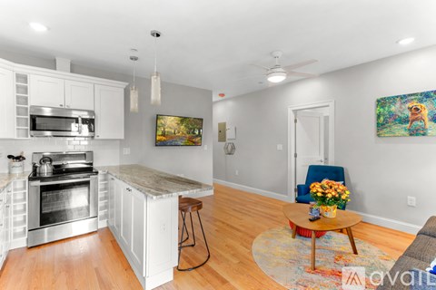 A kitchen with white cabinets and a painting on the wall.