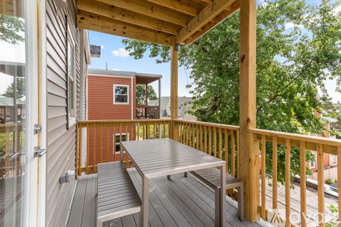 A wooden deck with a table and bench.
