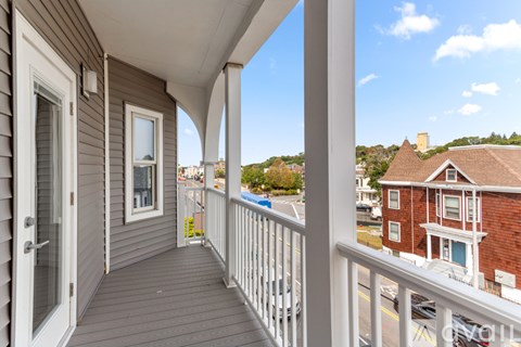 A balcony with a view of a street and houses.