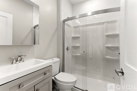 A bathroom with a toilet, sink, and shower.