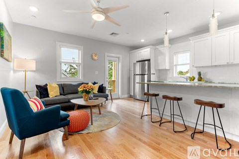 A living room with a blue chair and a grey couch.