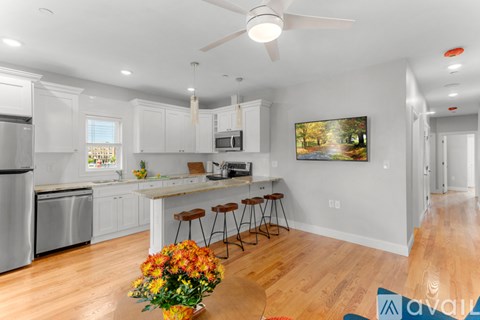 A kitchen with white cabinets and a wooden floor.