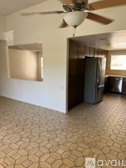 A room with a ceiling fan and a tile floor.