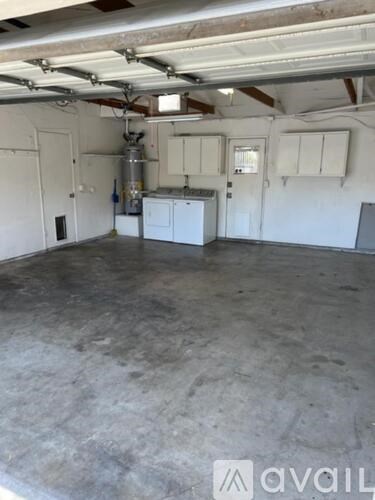 A large empty garage with a concrete floor and white walls.