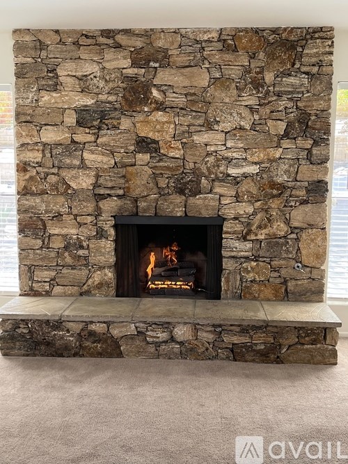 A stone fireplace with a fire burning inside.