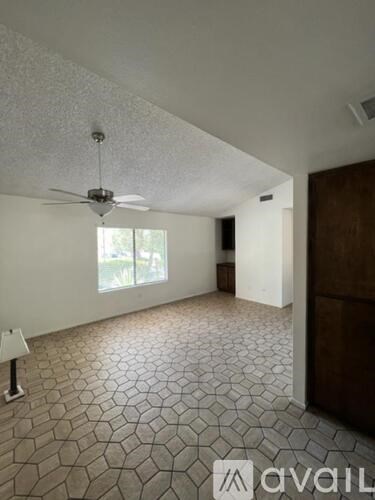 A room with a ceiling fan and a patterned floor.