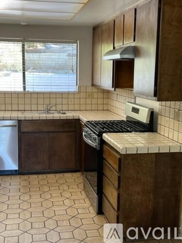 A kitchen with brown cabinets and a black stove top oven.
