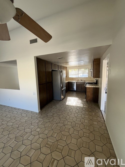A kitchen with tile flooring and a ceiling fan.