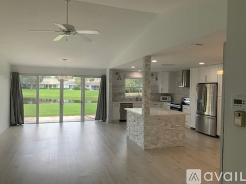 A modern kitchen with a stone island and stainless steel appliances.