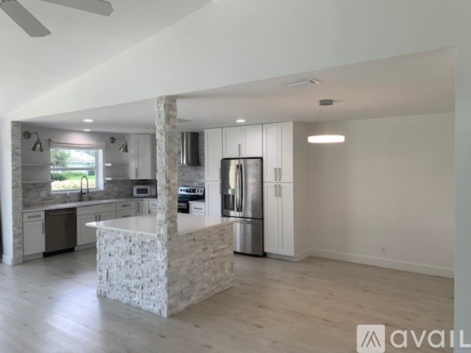 A modern kitchen with a stone island in the middle.