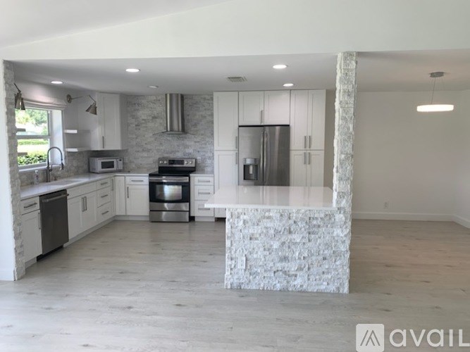 A modern kitchen with a stone island in the middle.