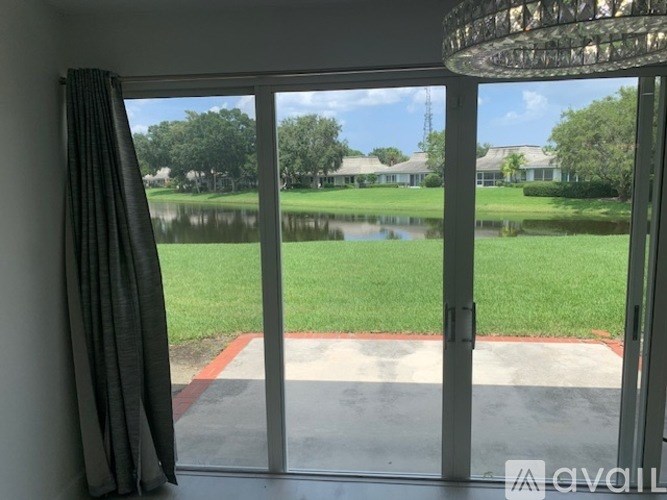 A view from a window looking out to a grassy area and a body of water.
