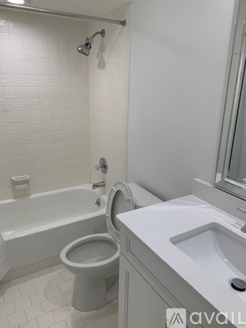 A white bathroom with a toilet, sink, and bathtub.