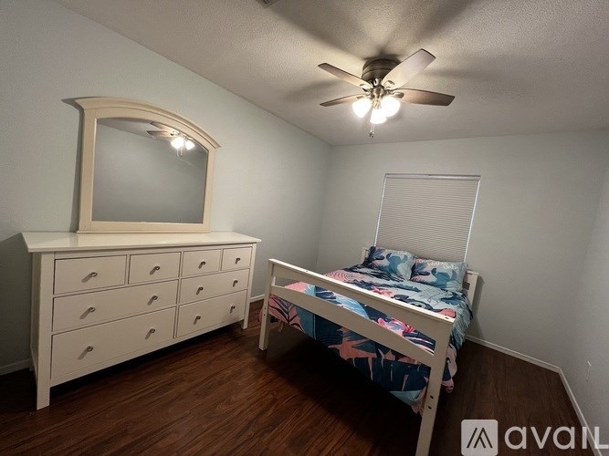 A bedroom with a bed, dresser, and mirror.