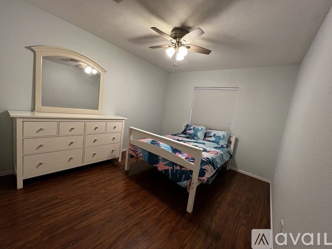 A bedroom with a bed, dresser, and mirror.
