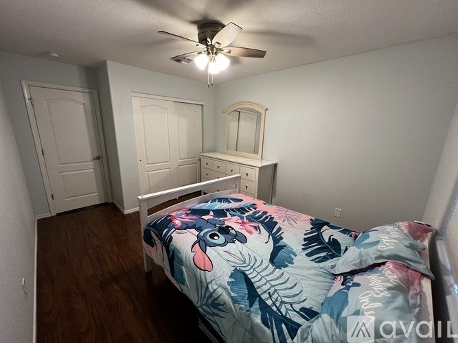A bedroom with a bed, dresser, and mirror.