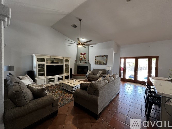 A living room with a couch, a chair, and a television.