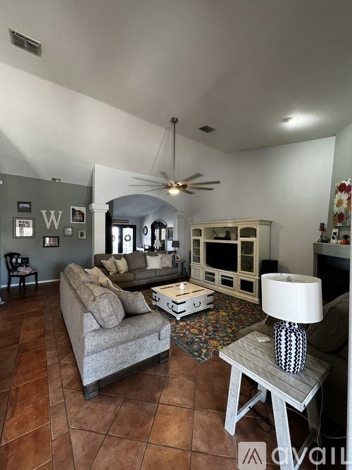 A living room with a grey couch and a white coffee table.