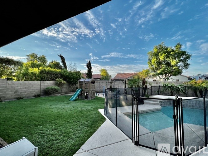 A backyard with a pool and a slide.