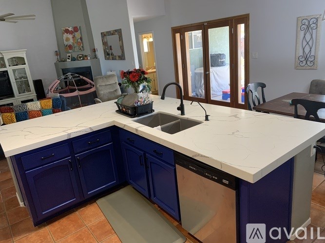 A kitchen with blue cabinets and a white countertop.