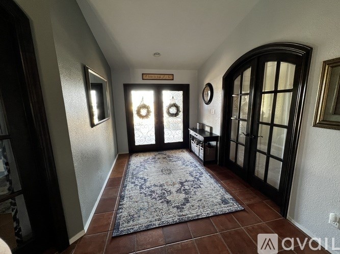 A hallway with a rug and a wreath on the door.