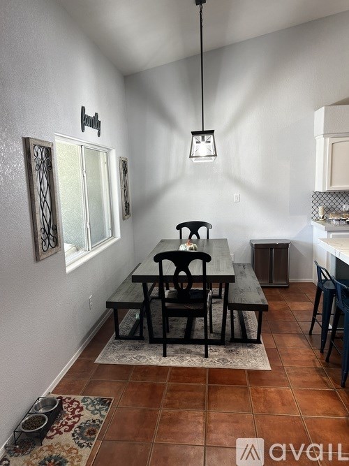 A dining room with a table and chairs.