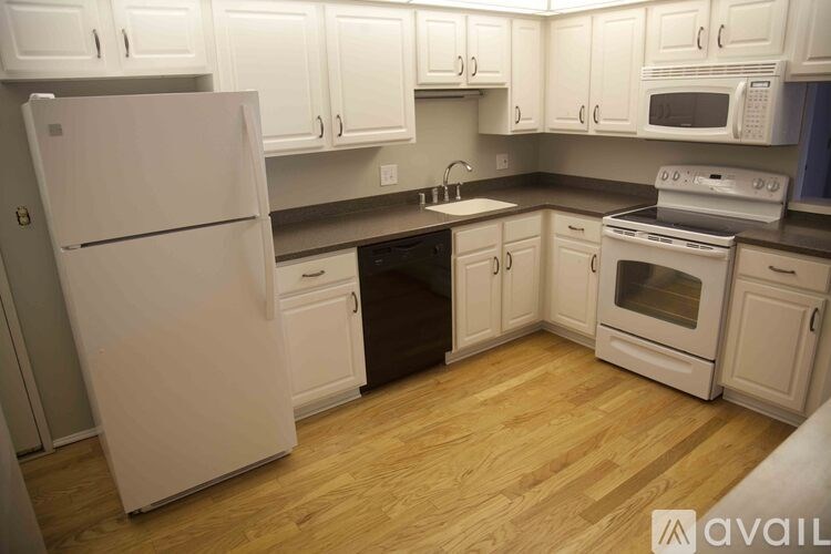 A kitchen with white appliances and cabinets.