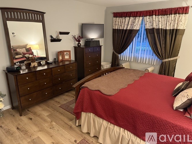 A bedroom with a bed, dresser, and mirror.