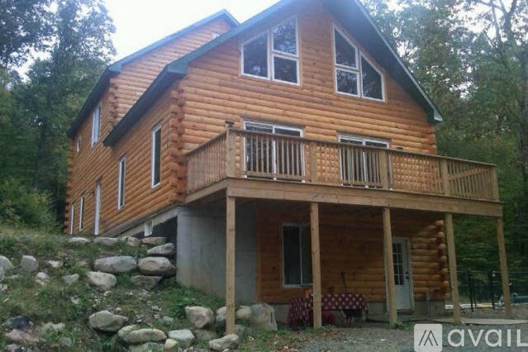 A wooden house with a balcony is available for rent.