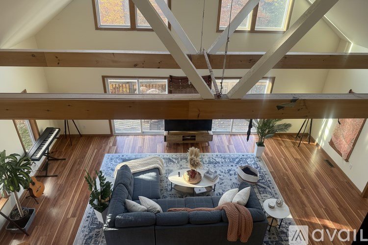 A living room with a grey couch and a wooden floor.